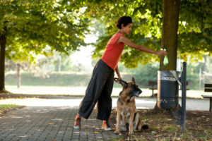 Woman throwing away dog poop bag