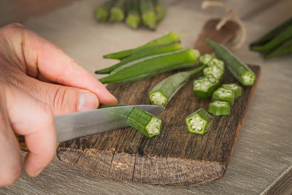 Preparing okra on a cutting board